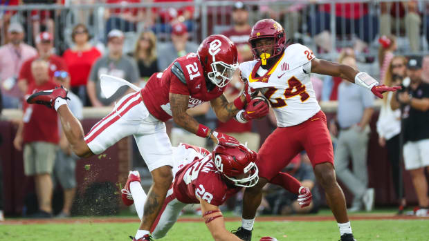 Oklahoma Sooners defensive back Reggie Pearson (21) and Oklahoma Sooners linebacker Danny Stutsman (28) tackle Iowa State Cyclones running back Abu Sama III (24)